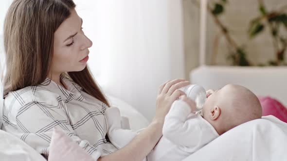 Mother Giving Bottle to Infant