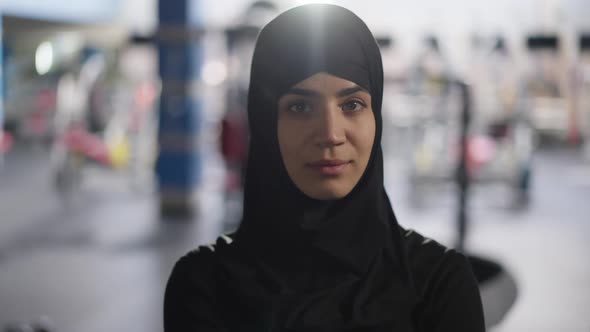 Portrait of Gorgeous Young Beautiful Middle Eastern Woman in Hijab Turning to Camera Standing in Gym