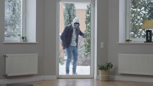Wide Shot of Thief Standing Behind Glass Door Looking Inside House
