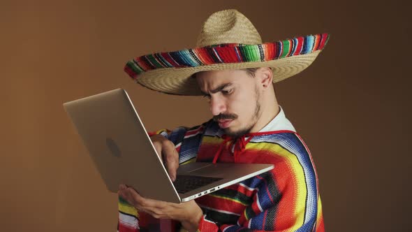 Young Mexican In Multicolored Poncho And Hat