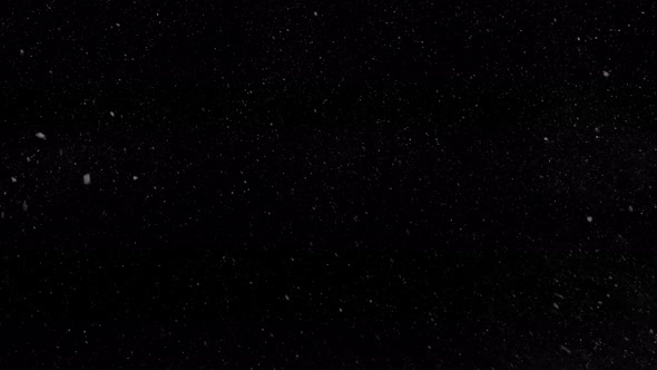 Falling snow isolated on black background in 4K to be used for composing, motion graphics.  alt