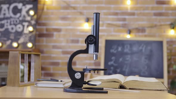 Empty Classroom with Chalkboard Desk Microscope and Textbook