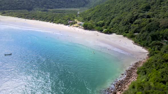 Aerial drone view of tropical deserted paradise beach with rocky coast and atlantic forest turquoise