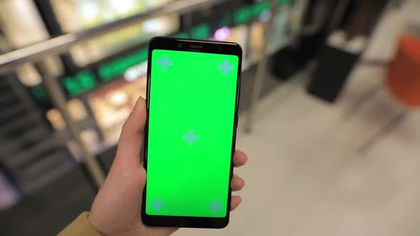 POV, Female Hand Holding Smartphone Green Screen in a Mall