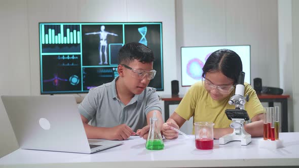 Young Asian Boy And Girl Learning Science Experiment. Study With Scientific Equipment