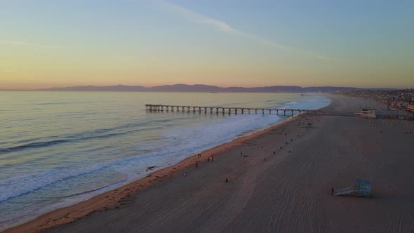Aerial drone uav view of a pier at sunset at the beach and ocean.