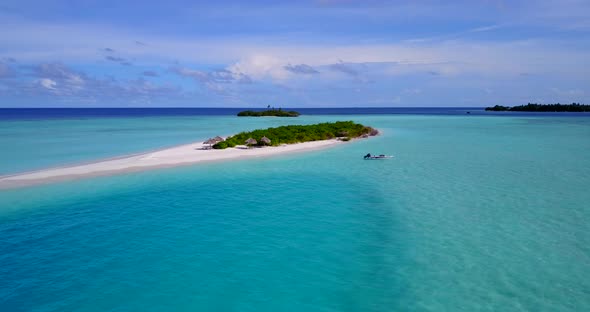 Wide angle fly over travel shot of a white paradise beach and blue water background in colorful 4K