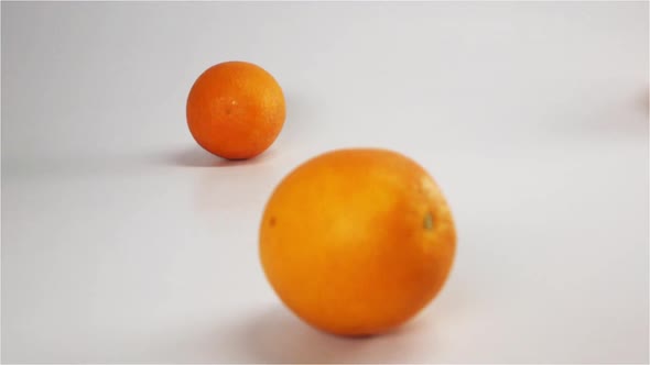 Oranges Fall and Bounce on White Wet Surface