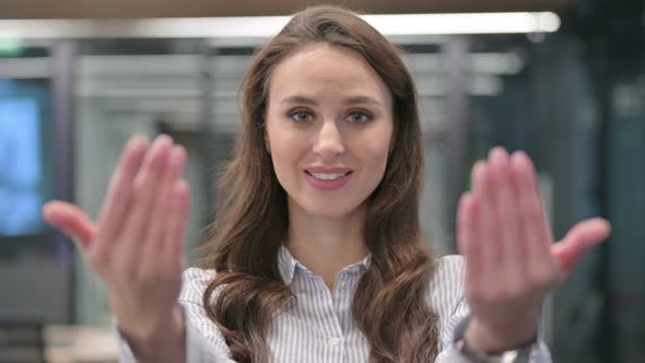 Portrait of Young Businesswoman Pointing at Camera, Inviting