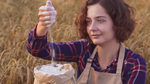 Close Up Of Happy Woman Pouring Flour In Wheat Field. Organic Flour Production, Organic Agricultural