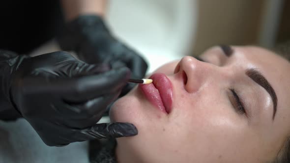 Closeup Applying Soothing Moisturizer on Lips of Client After Microblading Procedure