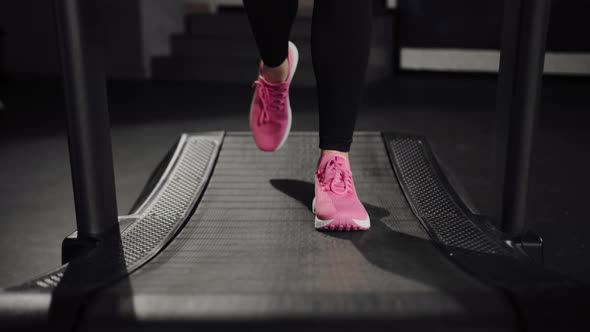 Close-up of sneakers: a girl athlete runs on a treadmill in the gym