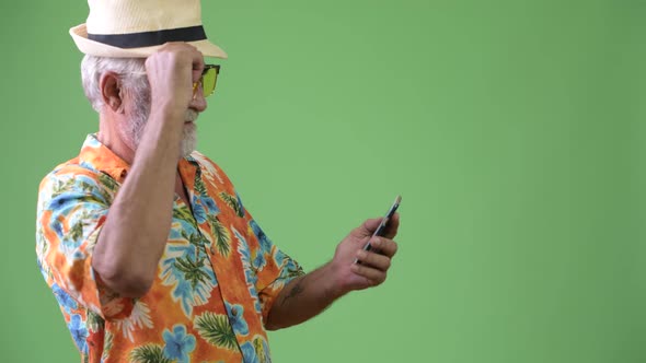 Handsome Senior Bearded Tourist Man Ready for Vacation Against Green Background