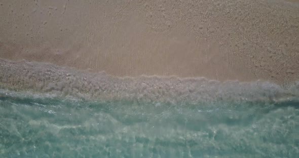 Daytime flying island view of a white sand paradise beach and blue sea background in vibrant 