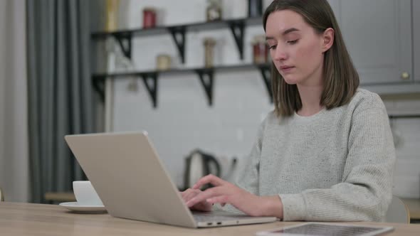 Focused Young Woman Working on Laptop in Living Room 