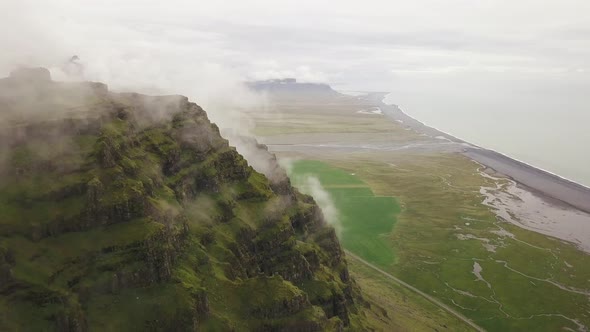 An aerial of a mountain with clouds on top in iceland