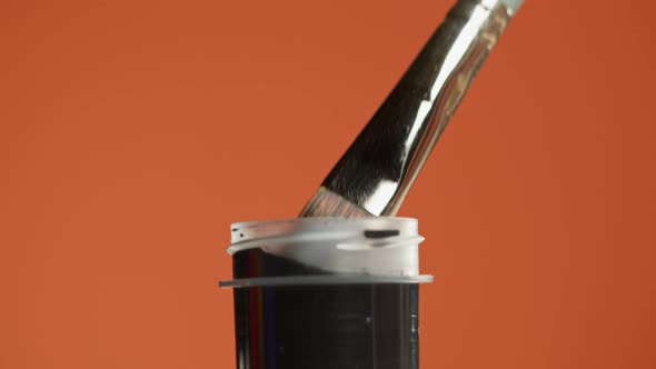 Black Paint Isolated on Orange Background alt