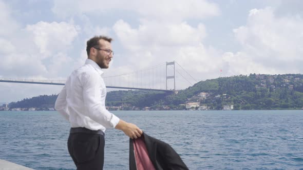 Man wearing his jacket against the city by the sea.