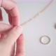 Stylish young woman chooses golden rings and tries on fingers against table - VideoHive Item for Sale