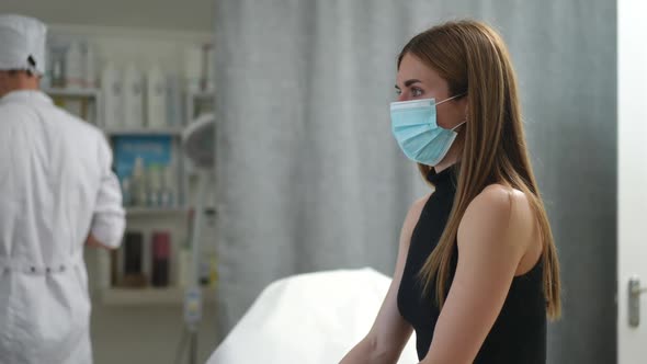 Side View Young Beautiful Woman in Face Mask Sitting in Vaccination Center Waiting for Blurred