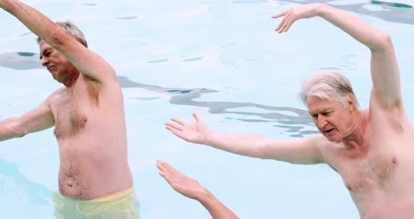 Seniors performing exercise in swimming pool