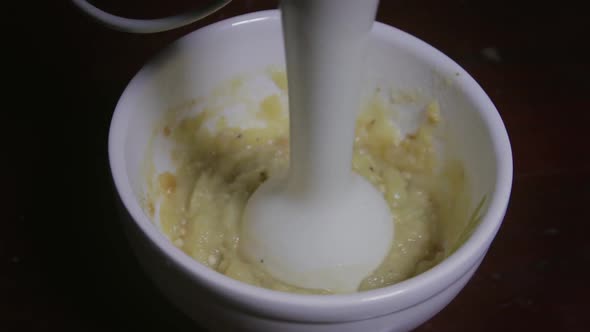 eggplant being processed for pure in a cup with a handblender