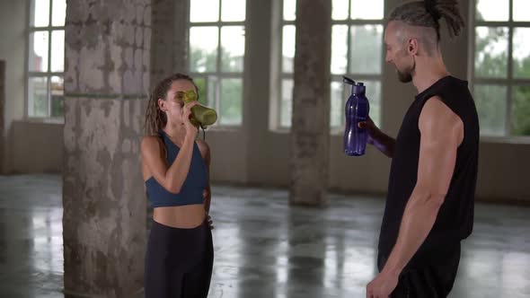 Stylish Sporty Man and Woman Standing in Studio Sport Club with Windows Background and Talking