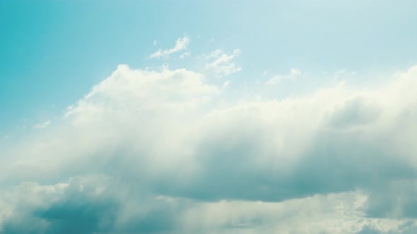 Sun Rays Shining Through Cloudy Sky With Fluffy Clouds