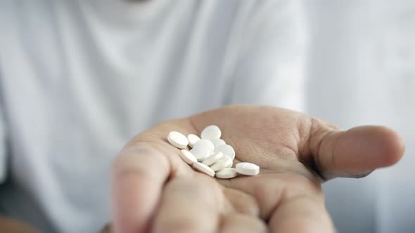 Man's Hand with Medicine Spilled Out of the Pill Container