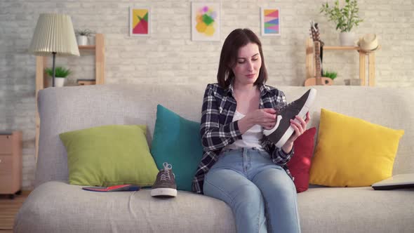 Young Woman Inserts an Orthopedic Insole Into the Shoe