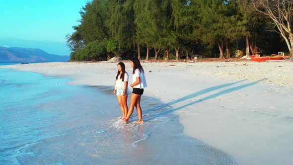 Women tan on idyllic coast beach adventure by blue lagoon with white sandy background of Gili Trawan