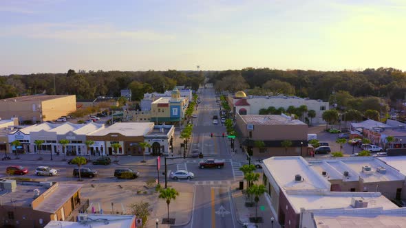 Forward Pan of Shops and Restaurants on the Main Road of a Small Town at Sunset