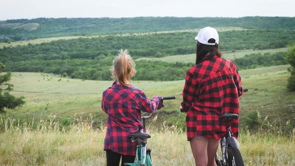 Young Mother and Daughter with Bikes on Mountain.