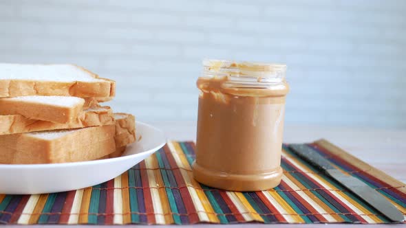 Peanut Butter and Stack of Bread on Table