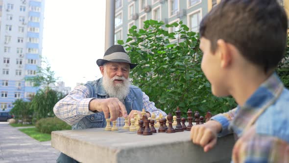 Old Aged Grandpa Teaching His Grandson Play Chess