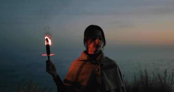 Young girl walks in the night with a fire torch