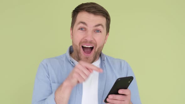 Young Man with a Smartphone in His Hands He Looks Shocked Surprised Wow Isolated on a Background