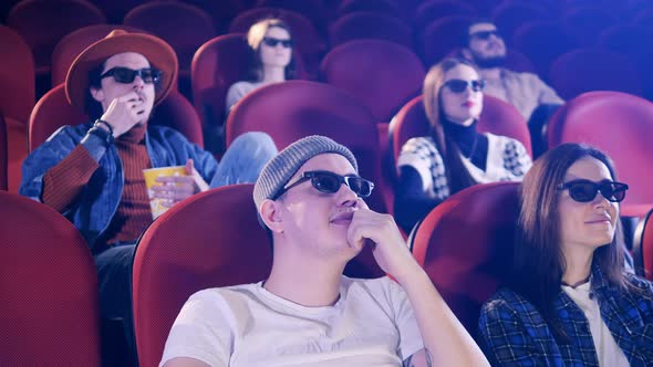 Rude Man Puts His Feet Up and Throws Popcorn at the Movie Theater