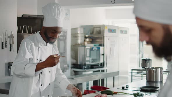 African American Man Taste Testing Vegetable Soup on Stove