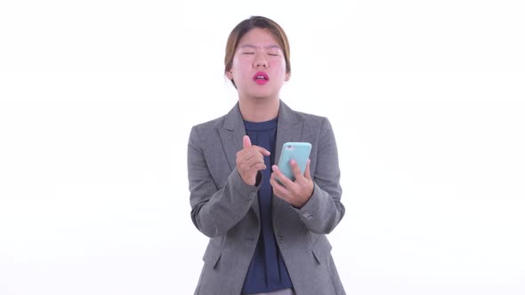 Stressed Young Asian Businesswoman Using Phone and Getting Bad News
