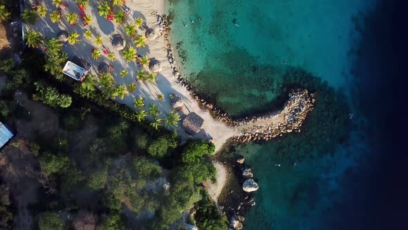 Dolly in overhead aerial view of the shore of Blue Bay beach in Curacao, Dutch Caribbean island