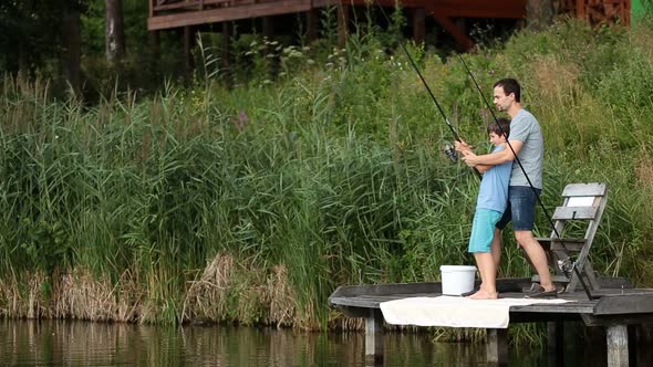 Father and Son Stretching Rod with Fish on Hook