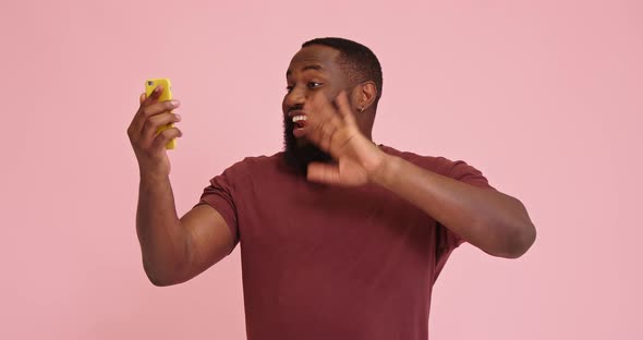 Young African American Man Make Video Call Isolated on Pink Background