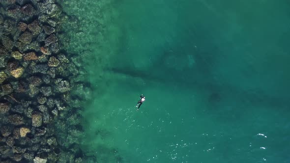 One person snorkeling above a sunken city urban infrastructure treated sewer pipe outlet in a popula