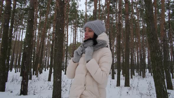 A Girl in the Winter Forest Looks Dreamily Into the Sky