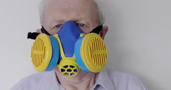 Close Portrait of Senior Man Wore in Universal Respirator Looking Into Camera