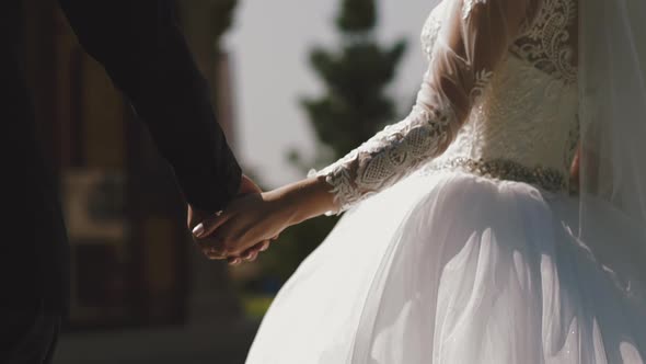 Bride in Gorgeous Dress Joins Hands with Groom on Street
