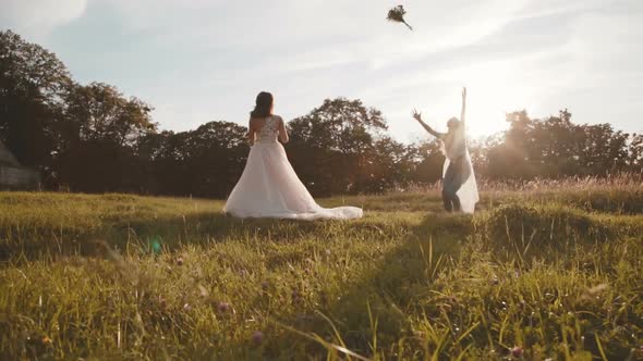 Happy Bride Throwing the Wedding Bouquet To Bridesmaid on Sun Blinks