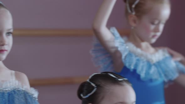 Ballet Training  Four Ballerina Girls in Blue Dresses Standing in Their Dance Positions