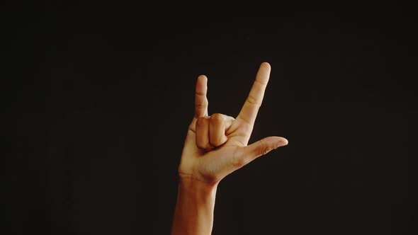 African American Man Showing Rock and Roll Gesture with Fingers Isolated on Black Background